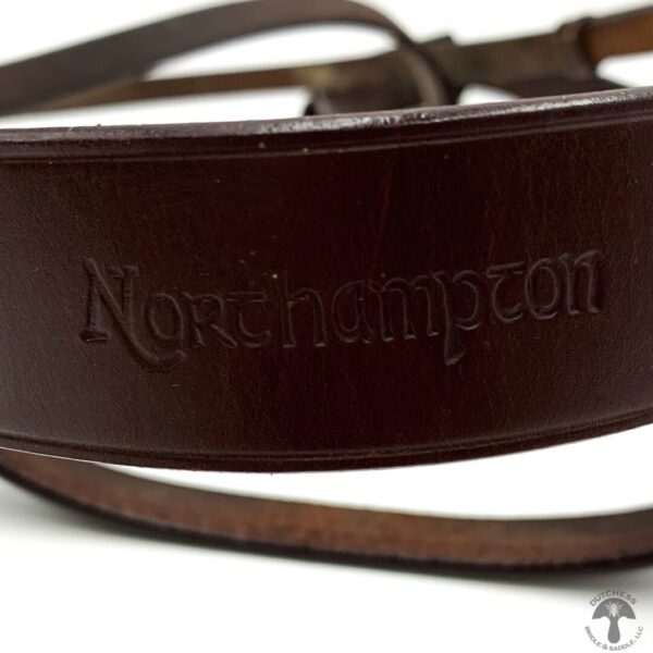 A close up of the northampton logo on a brown leather strap.