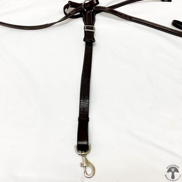 A black leather strap with a silver hook hanging from it.