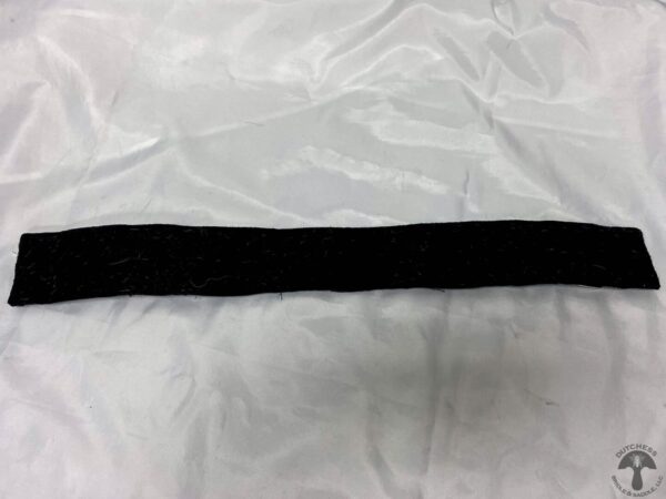 A black strip of fabric on top of white cloth.