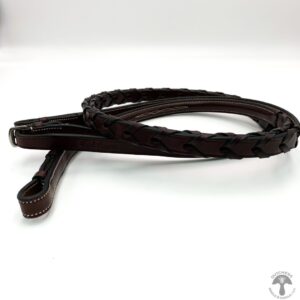 A brown leather reins on top of a white table.