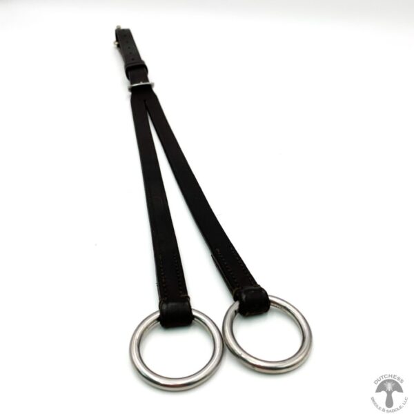 A pair of metal rings hanging from black straps.