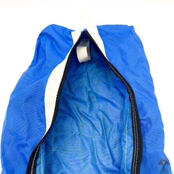 A blue bag with a white strap and black handle.