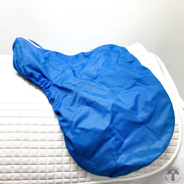 A blue bag sitting on top of a bed.