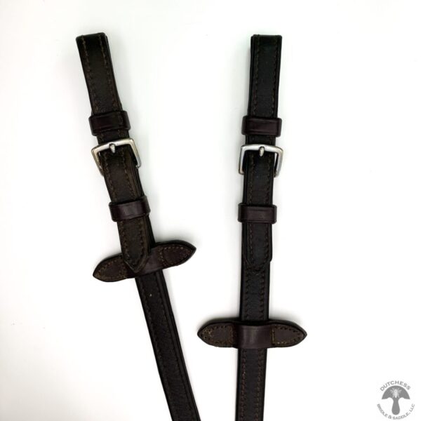 A pair of black leather suspenders with metal buckles.