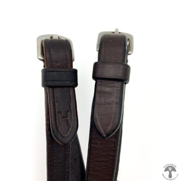 A pair of brown leather straps with silver buckles.