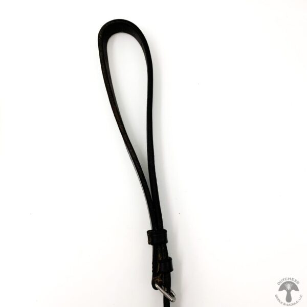 A black leather strap hanging on to a white wall.