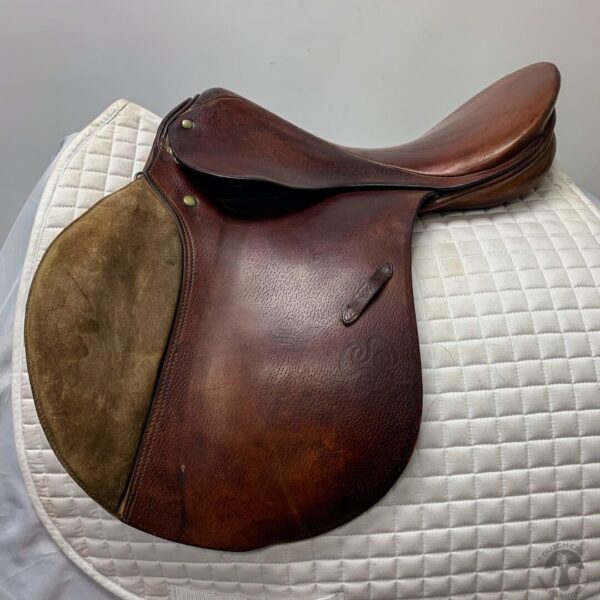 A saddle sitting on top of a white cushion.