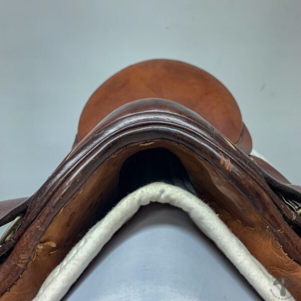 A close up of the saddle with the seat and stirrups.