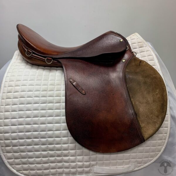 A saddle sitting on top of a white pad.