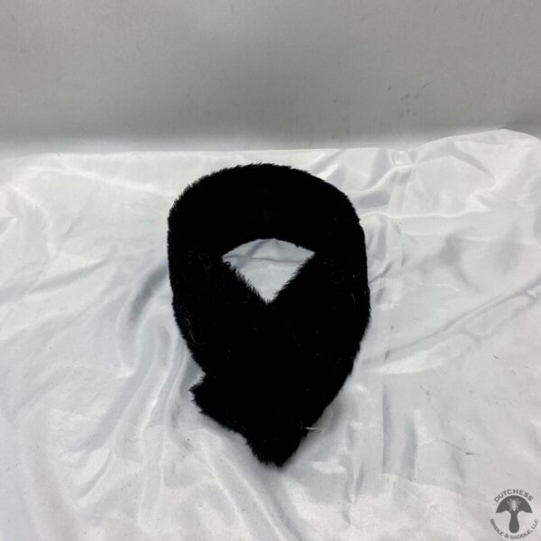 A black scarf is laying on the bed