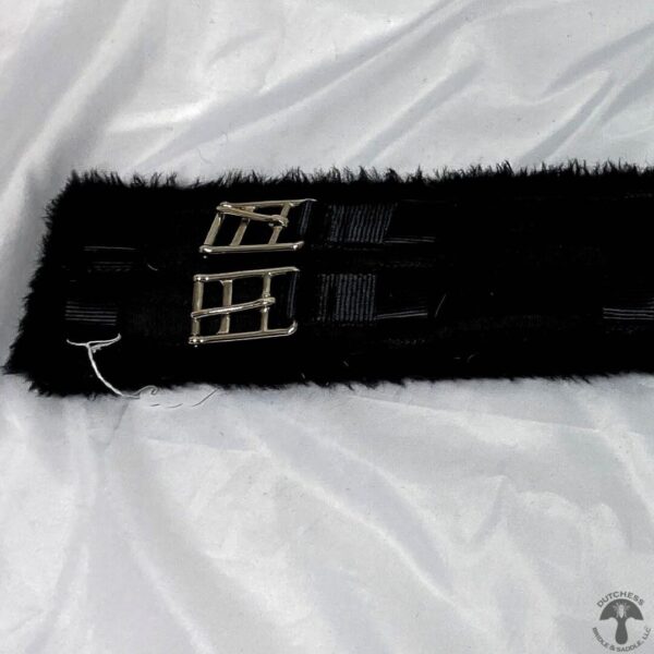 A black furry pillow with a white ribbon around it.