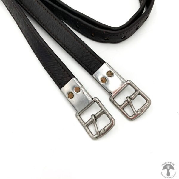 A pair of black leather straps with silver metal buckles.