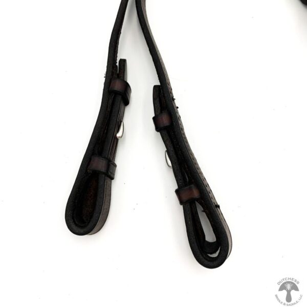 A pair of black leather straps hanging on a wall.