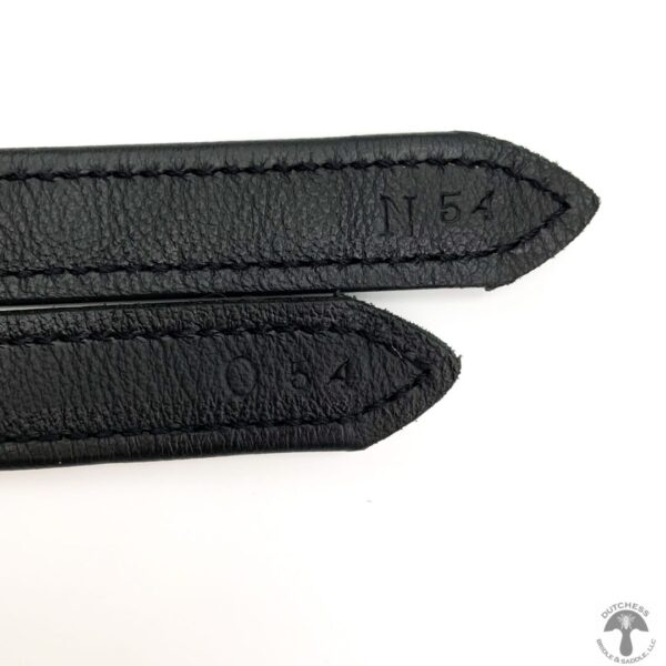 A pair of black leather straps with stitched edges.