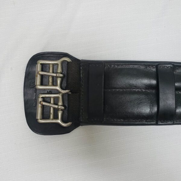 A close up of the buckle on a black belt