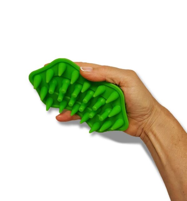 A hand holding a green toy in the shape of an alligator.