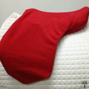 A red pillow on top of a bed.